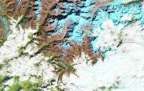 The false-color images above show a glacial lake in the Himalayas nearly doubling in length over 30 years. Ice is represented as light blue, while significant meltwater is dark blue. Rocks are brown; vegetation is green.
